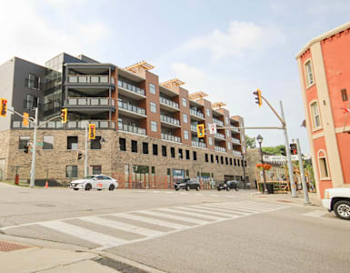 A street view of a multi-story building with a parking lot in front.
