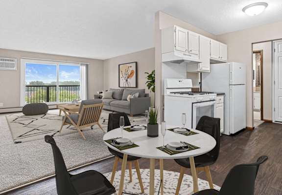 A modern kitchen with white appliances and a dining table set for two.