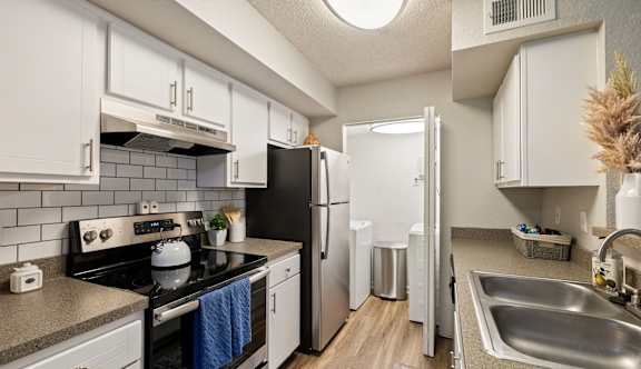 A kitchen with white cabinets and a black stove top oven.