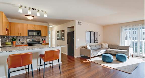 A kitchen with orange chairs and a white counter.