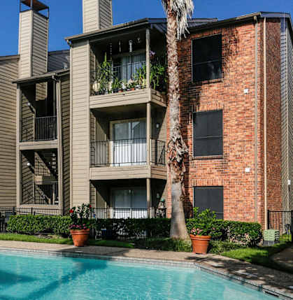 A large apartment complex with a pool in front.