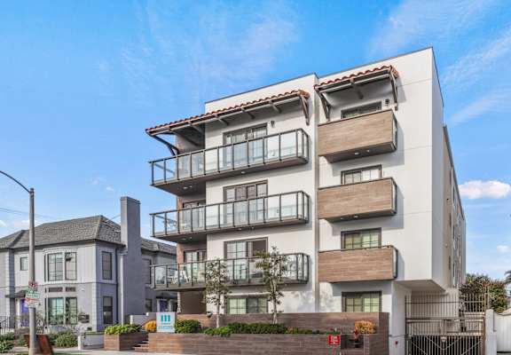 a white apartment building with balconies on the side of a street
