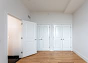 Thumbnail 21 of 23 - Three white doors in a room with wooden floors.
