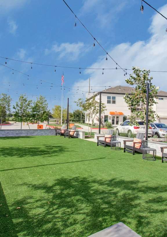 A park with a green lawn and benches.