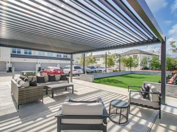 a patio with couches and tables and a large canopy
