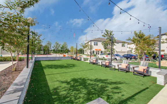 a yard with benches and a pool with lights