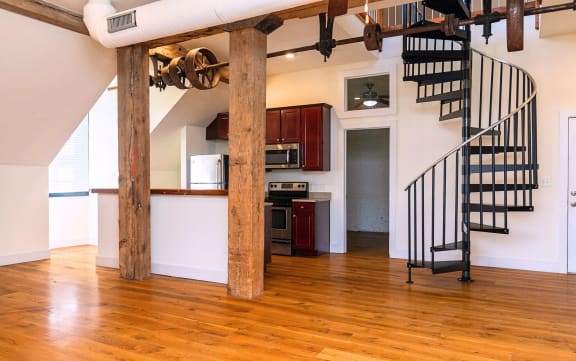 a living room with a spiral staircase and a kitchen