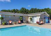Thumbnail 6 of 13 - A pool in front of a small building with a sign on it.
