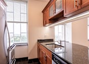 Thumbnail 20 of 23 - A kitchen with a refrigerator, sink, and cabinets.