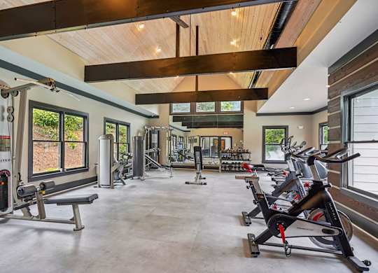 A spacious gym with a variety of equipment including treadmills, stationary bikes, and weight machines.