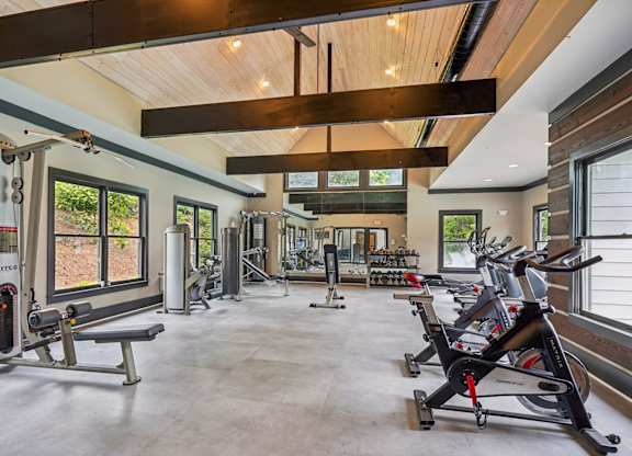A spacious gym with a variety of equipment including treadmills, stationary bikes, and weight machines.