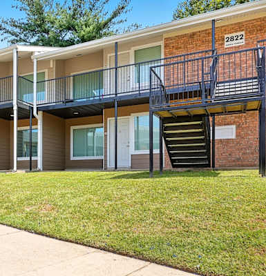 Apartment building with balconies and stairs leading to the second floor.