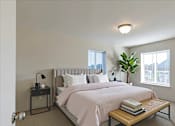 Thumbnail 2 of 8 - A bedroom with a large bed and a window with blinds.