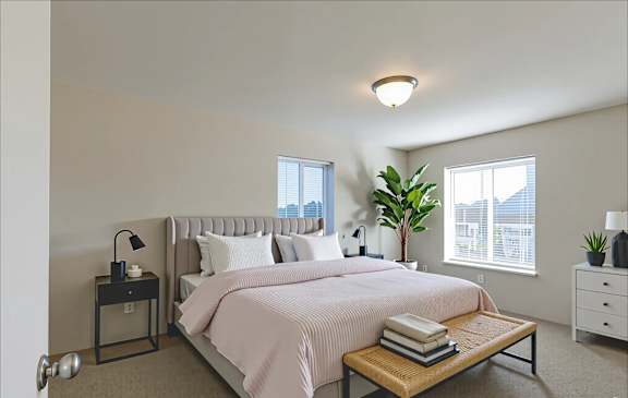 A bedroom with a large bed and a window with blinds.