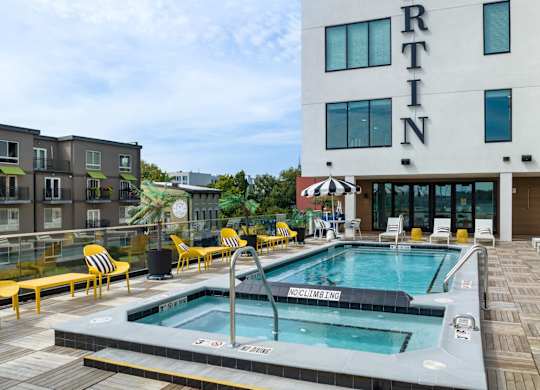 Studios in Nulu KY - Martin on Main - Rooftop Pool with Spa, Lounge Chairs, Tables, Chairs, Umbrellas, and Benches.