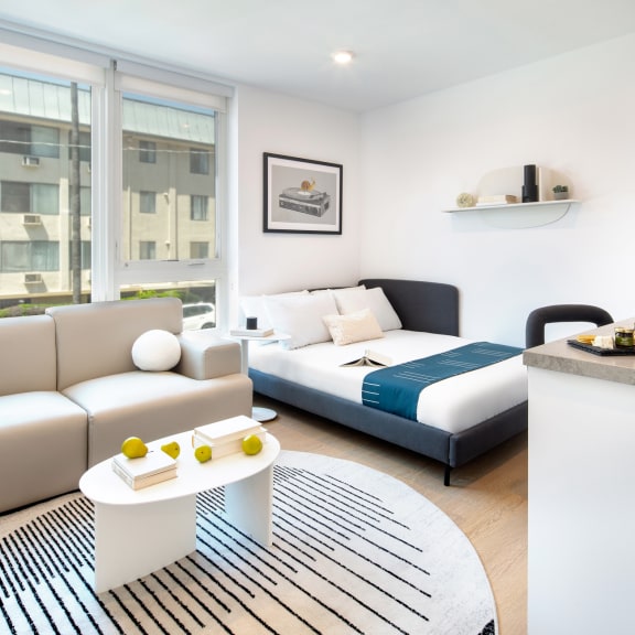 a kitchen and living room with white cabinets and a sink