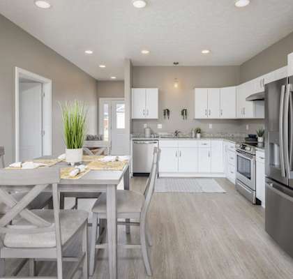 A modern kitchen with a dining table set for two.