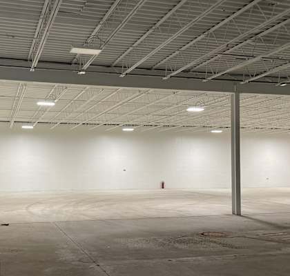 a large empty room with a fire hydrant in the corner