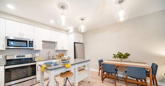 a kitchen with stainless steel appliances and a table with chairs