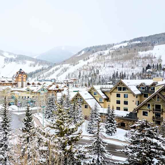 A snowy mountain town with a large building in the center.