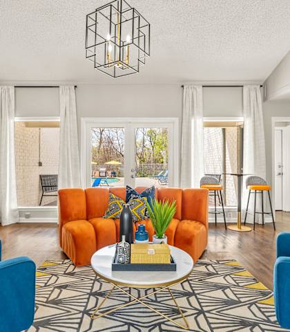a living room with blue and orange furniture and a coffee table at The Hudson, Texas, 75006