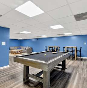 A room with a pool table and bar stools at Avondale Overlook Apartments in Hyattsville, MD 20782