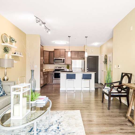 an open concept living room and dining area with a white dining table and rattan chairs