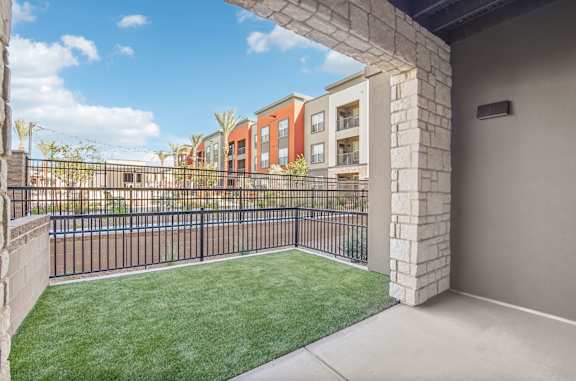 our apartments have a spacious balcony with grass and a fence at The Maddox Luxury Apartment Homes, Arizona, 85326