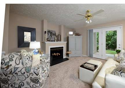 A living room with a fireplace and a ceiling fan.