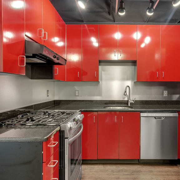 a kitchen with stainless steel appliances and blue and white cabinets at The Lofts at Elk Terminal Apartments , Buffalo, NY, 14202