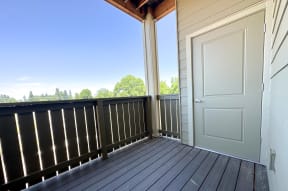 a balcony with a white door and a view of trees