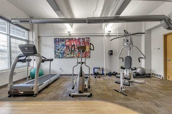 A gym with treadmills, exercise bikes, and weights.