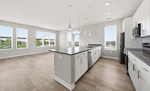 A modern kitchen with white cabinets and a large island.