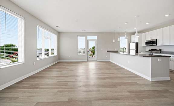 A spacious kitchen and living room with a large window.