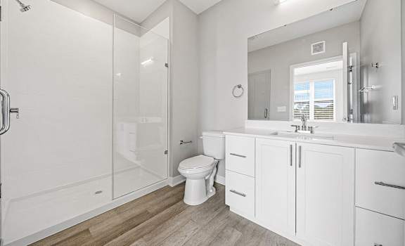 A white bathroom with a walk-in shower and a toilet.