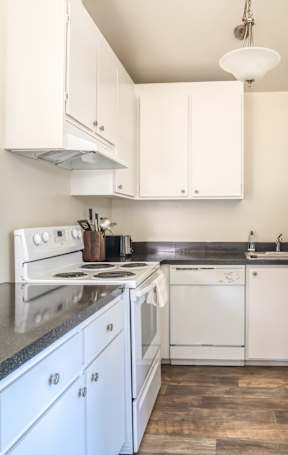 A kitchen with white appliances and cabinets.