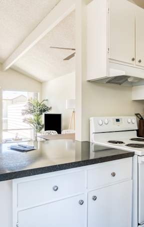 A kitchen with white appliances and cabinets.
