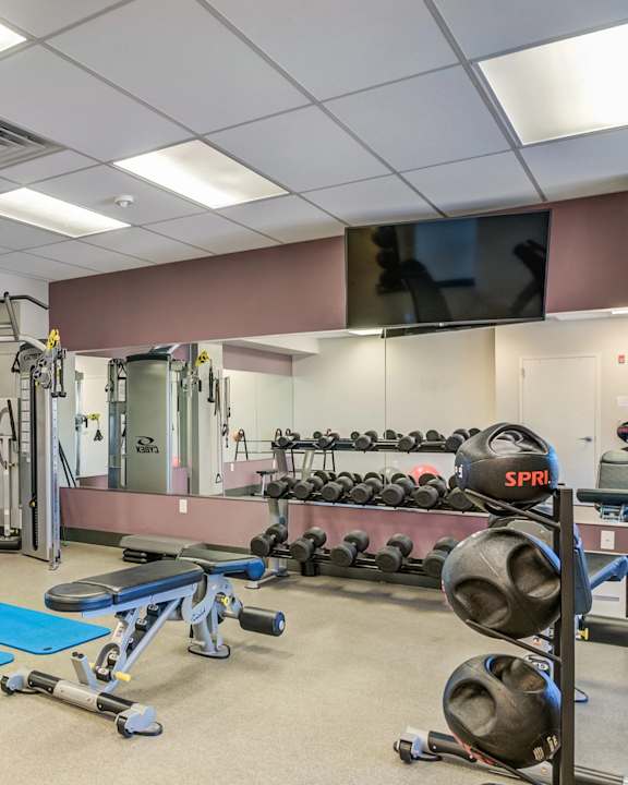 A gym with blue mats on the floor.