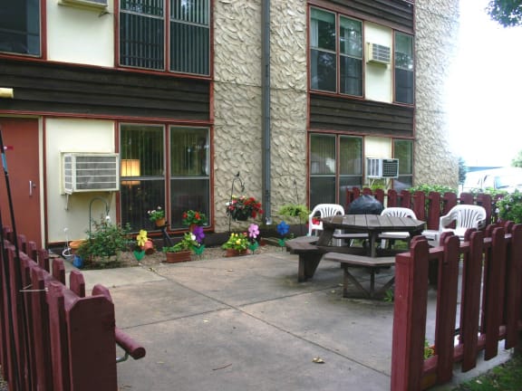 a patio with a table and chairs in front of a house