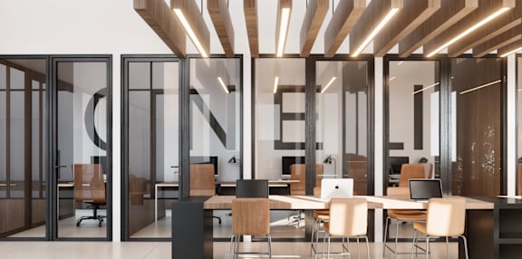 a large office space with desks and chairs and large glass doors