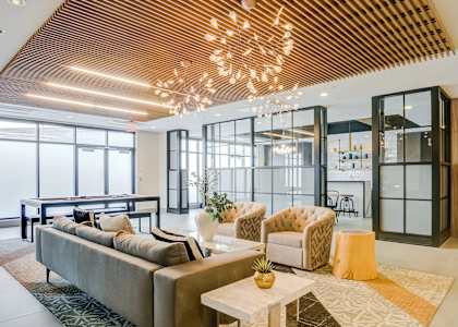 A modern living room with a large sofa and a wooden ceiling.