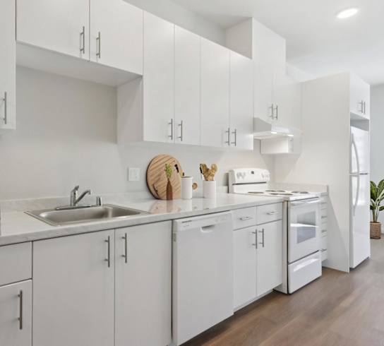 A modern kitchen with white cabinets and appliances.at Mainline North Apartments - Santa Clara, CA, California
