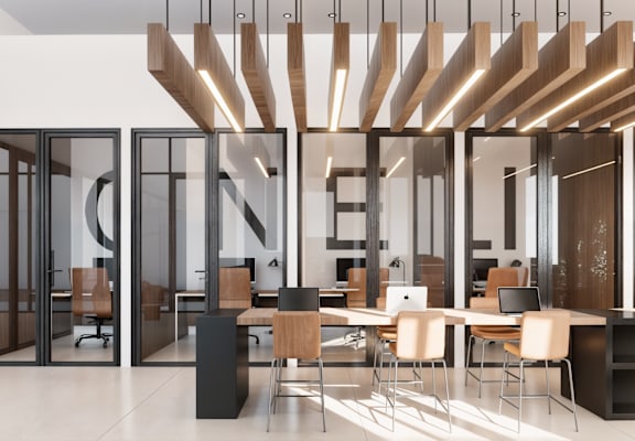 a large office space with desks and chairs and large glass doors