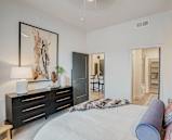 a bedroom with a large bed and a dresser