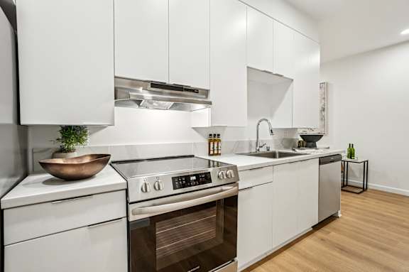 A modern kitchen with white cabinets and stainless steel appliances.