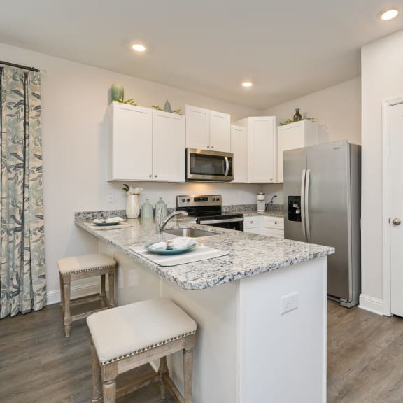 a kitchen with white cabinetry and a granite counter top