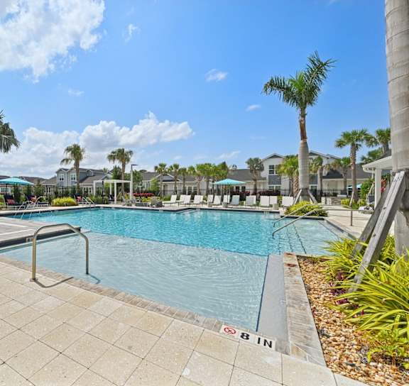 a swimming pool with palm trees and buildings in the background at The Sophia, Florida, 34275