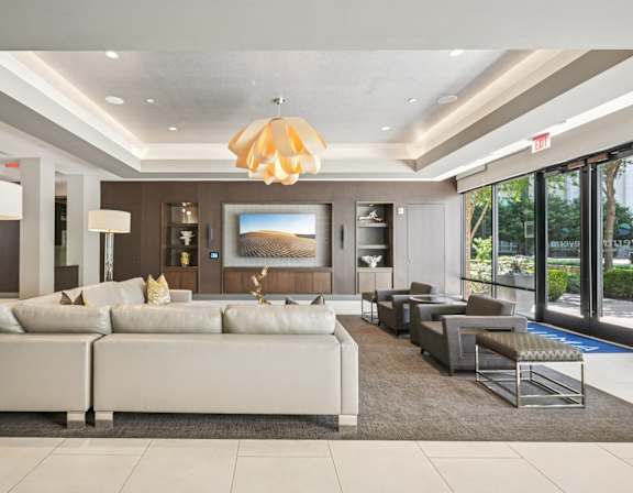 A modern living room with a large white sofa and a chandelier hanging from the ceiling.