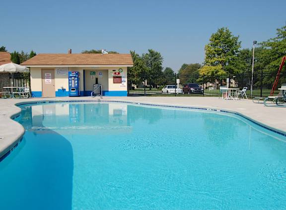 A large blue swimming pool in front of a small building.