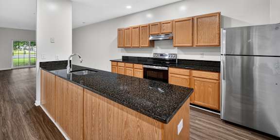A kitchen with wooden cabinets and a black countertop.